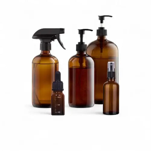 Auswahl brauner Glasflaschen mit verschiedenen Dosieraufsätzen auf weißem Hintergrund